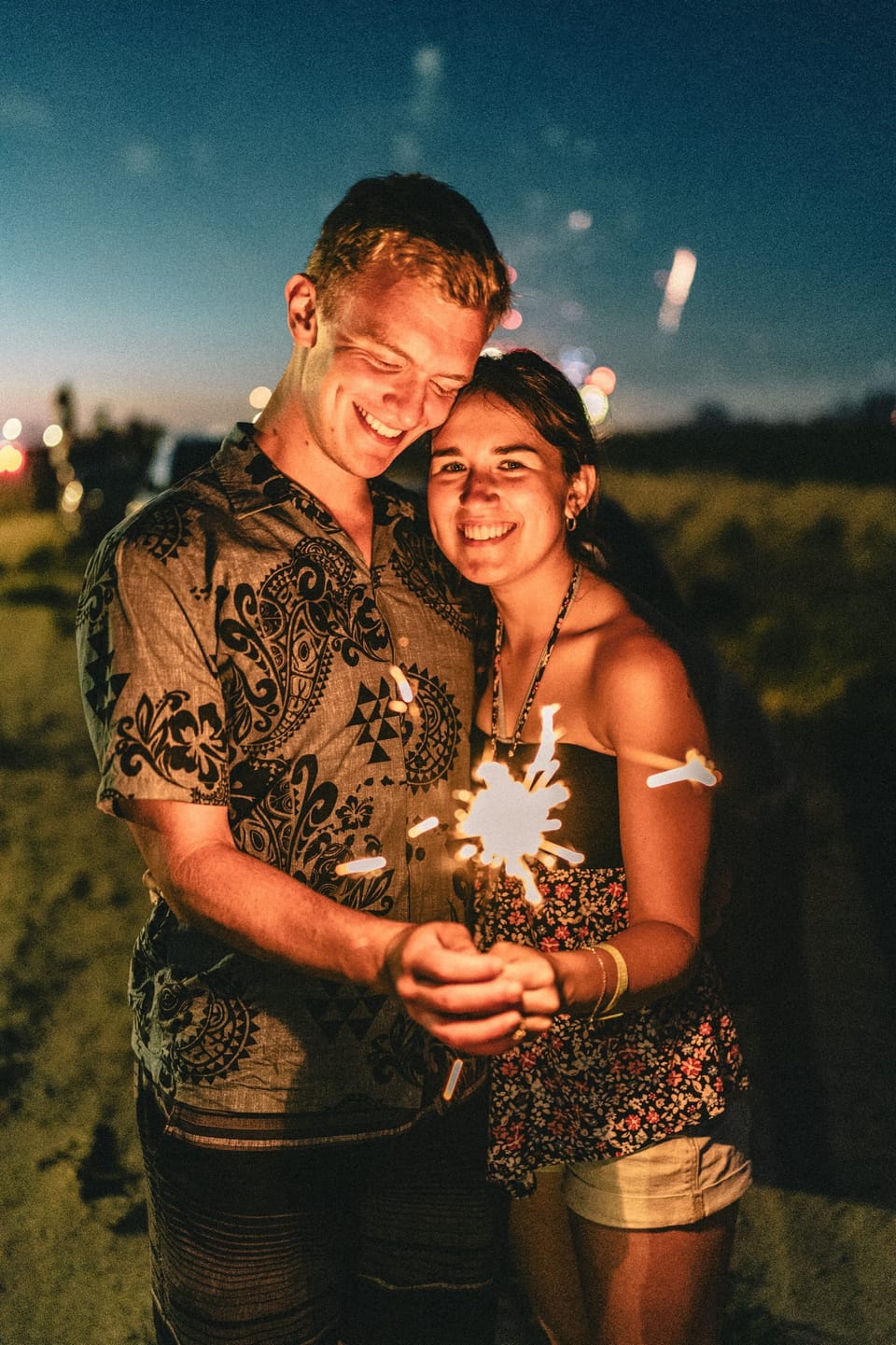 Couple embracing at night in the glow of sparklers