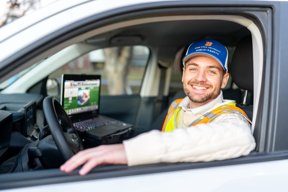 Graduate smiling from the driver's seat of a white truck