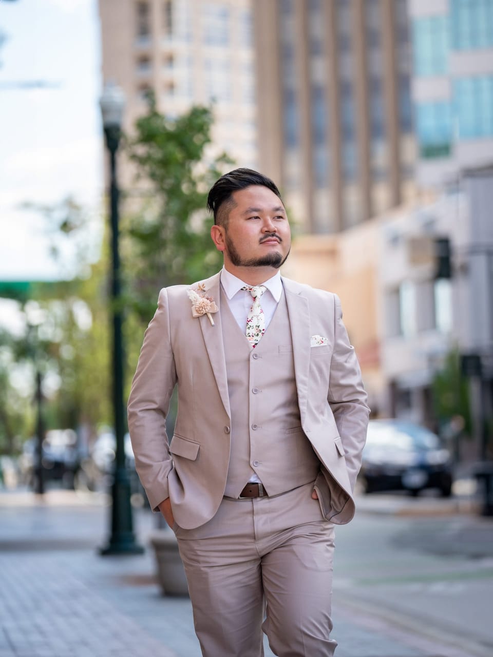 Man in a beige suit standing on a city street