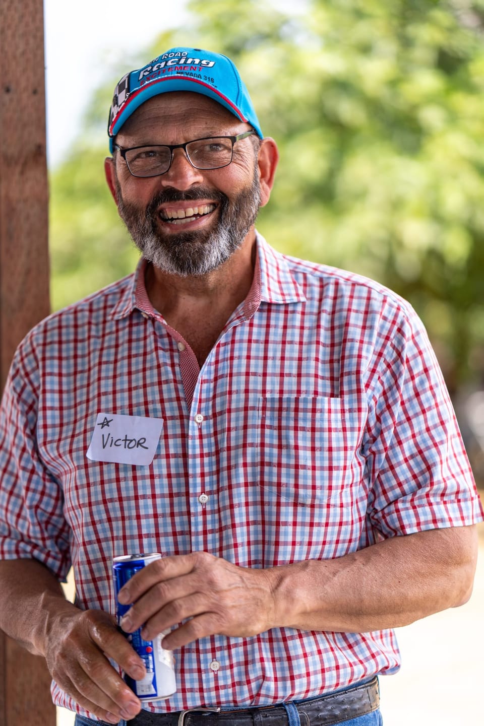 Laughing man in a plaid shirt and cap outdoors