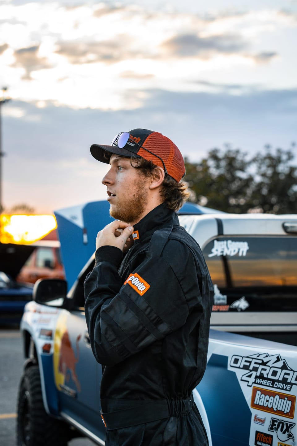 Man in a red cap and black jacket at a car show