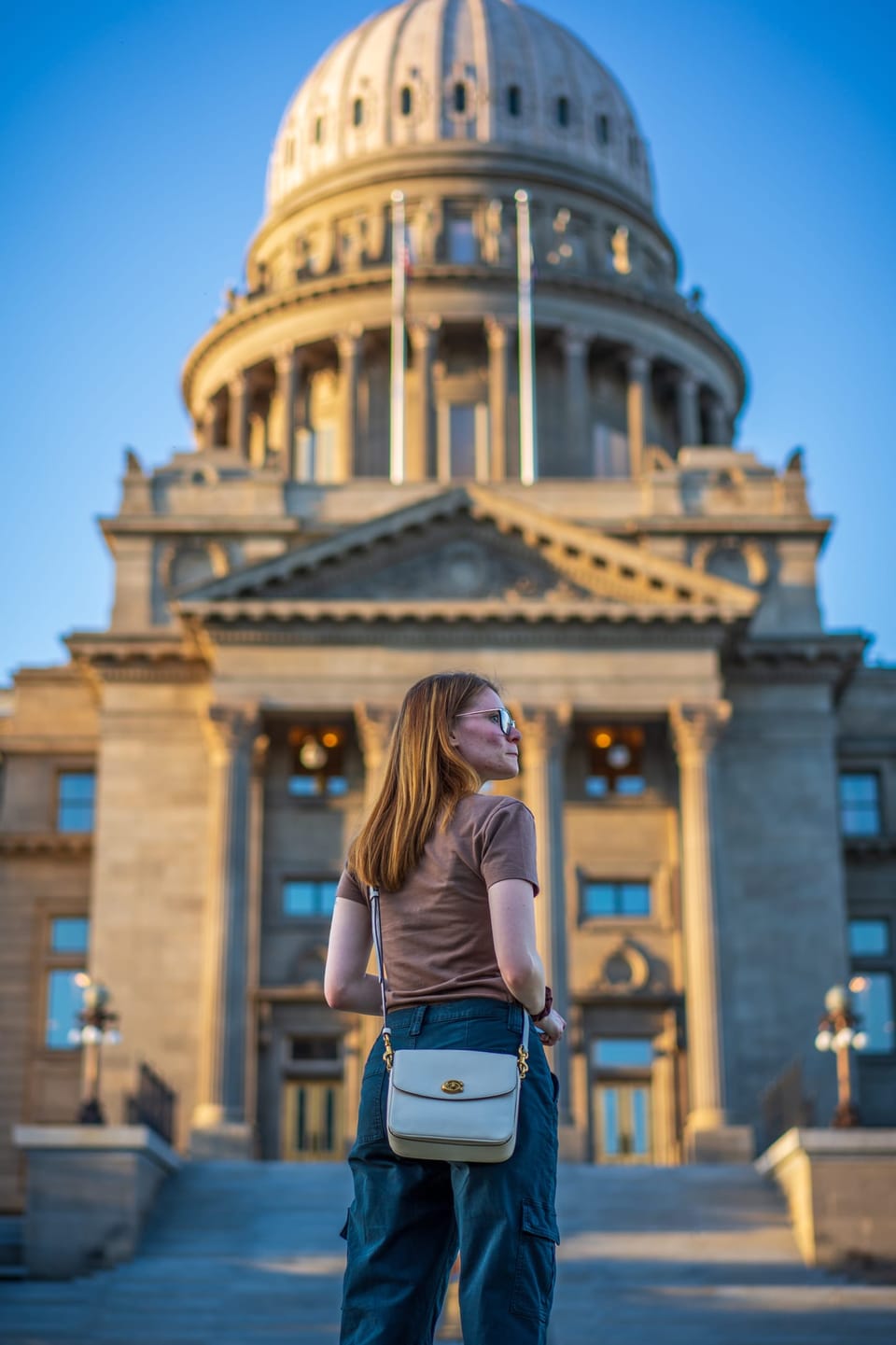 Woman walking in front of the Idaho State Capitol dome