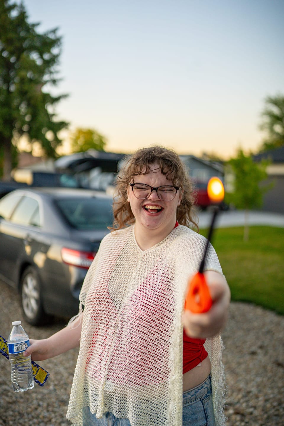Woman in a lace top laughing on a summer evening