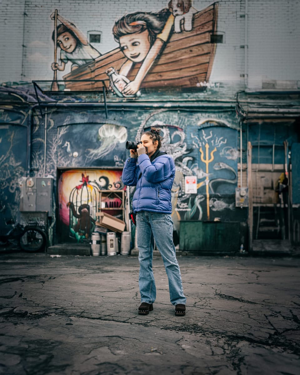 Woman standing in front of a colorful painted mural