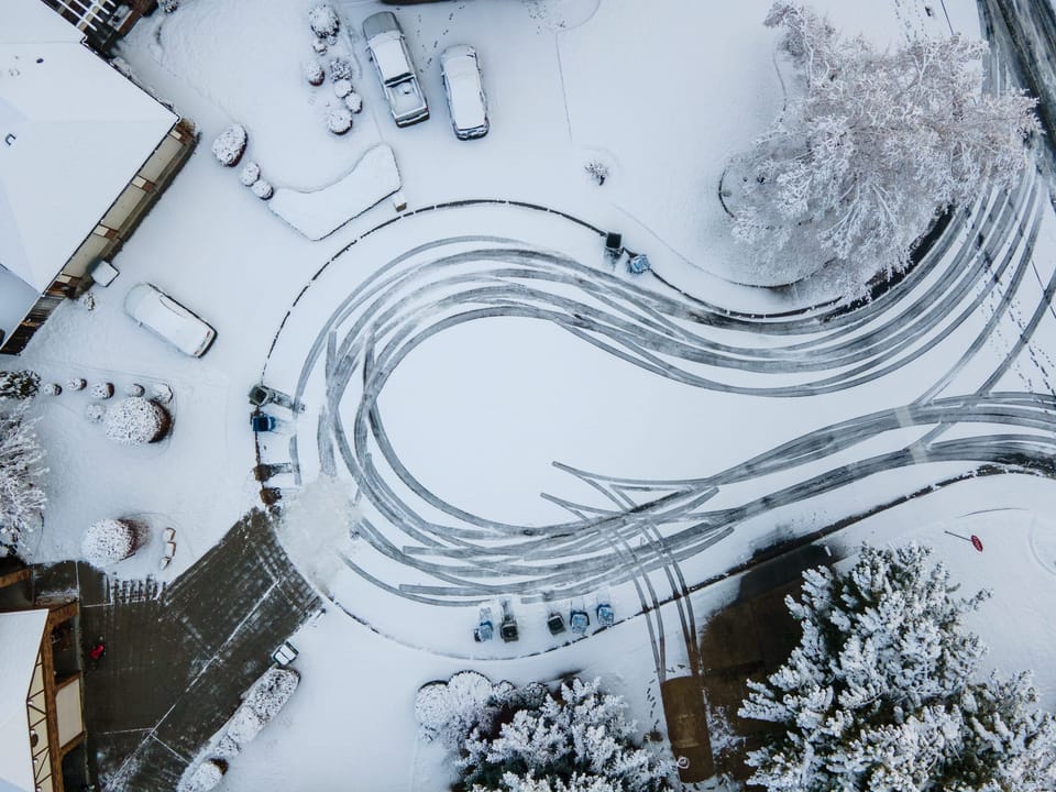 Top-down drone view of snowy streets curving through a neighborhood
