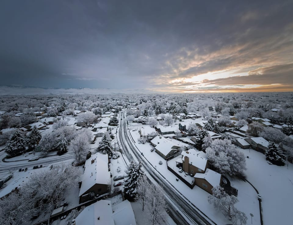 Aerial view of a snow-covered town under a moody winter sky