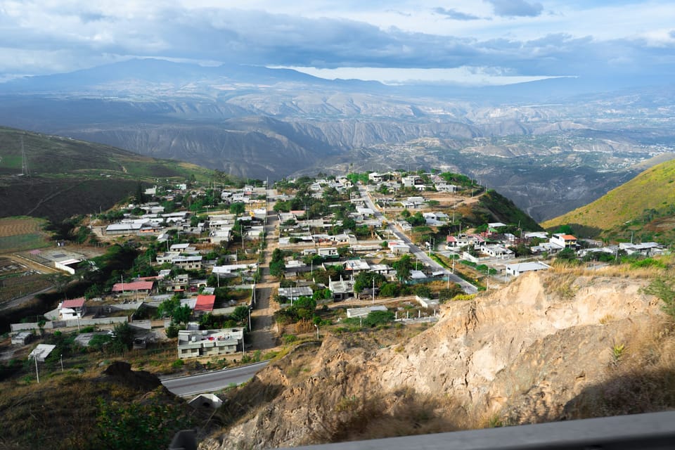 Hillside town spread across a valley below rugged mountains