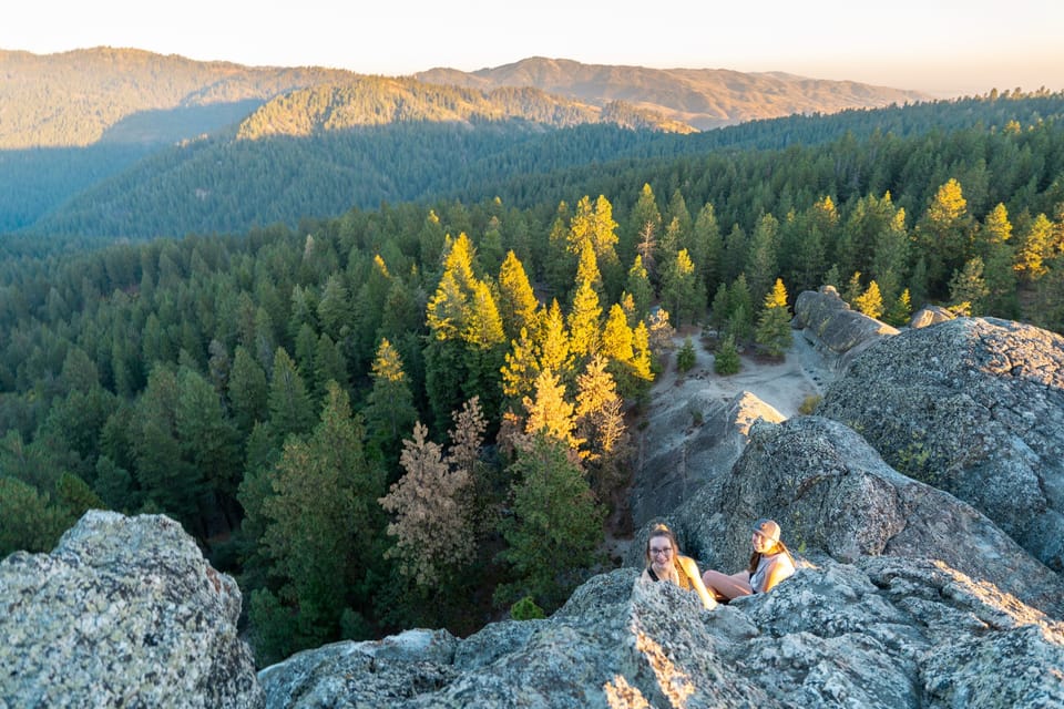 Rocky outcrop overlooking forested ridges and golden autumn trees