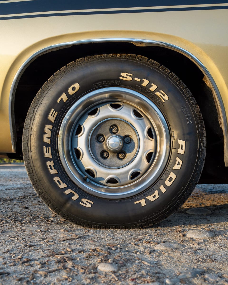 Chrome wheel and raised-letter tire of a classic Barracuda