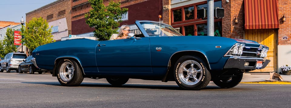 Classic blue convertible parked on a downtown street