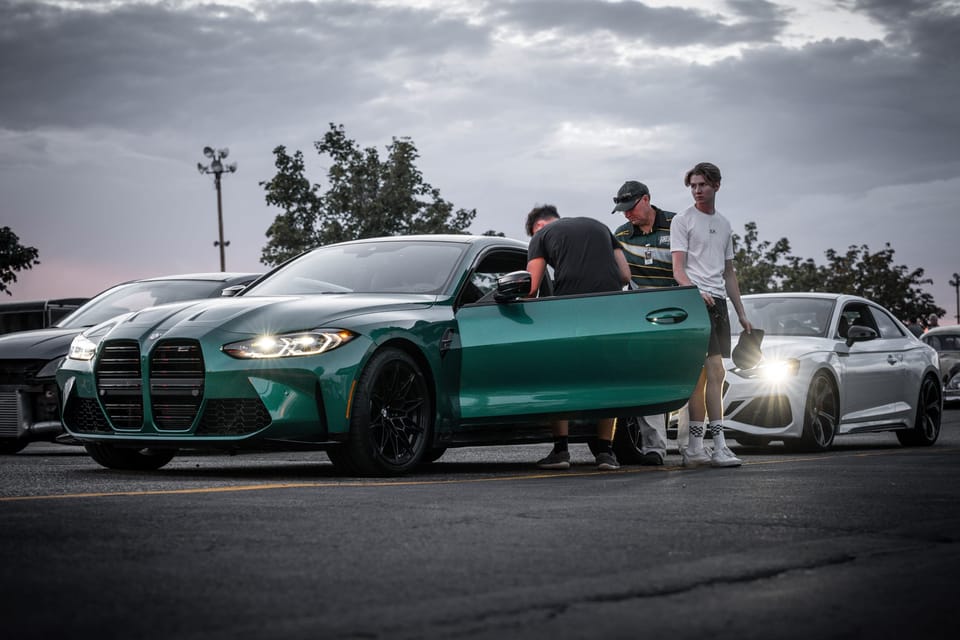 Green BMW at a car meet with people gathered around