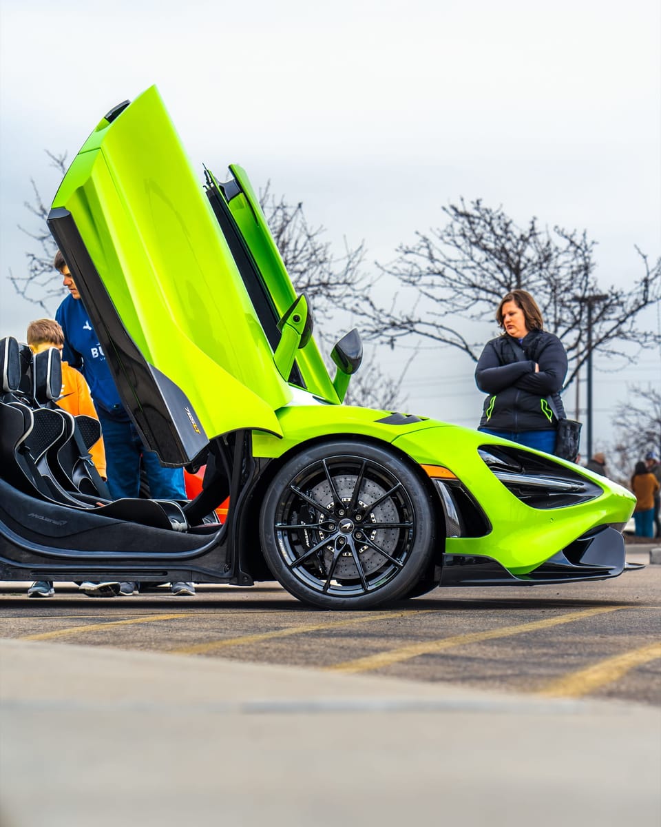 Lime-green McLaren with doors raised at a car meet